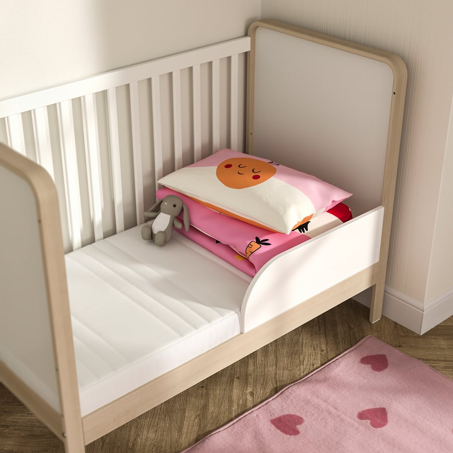 IKEA Jättetrött dentro de una cuna de madera con ropa de cama y un peluche