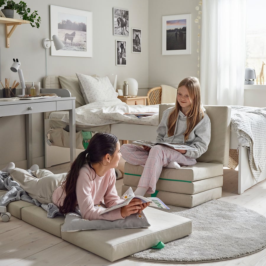 Dos niñas usan el IKEA SLÄKT como colchón y como asiento en un dormitorio infantil