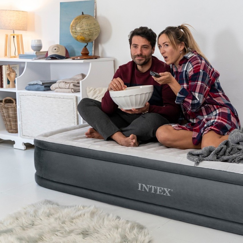 Pareja sentada sobre el Intex Comfort-Plush Elevated en un salón