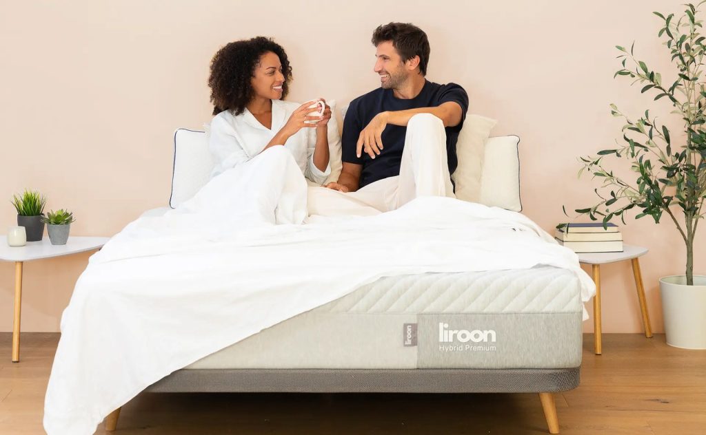 Pareja sentada en la cama con el colchón Liroon Hybrid Premium