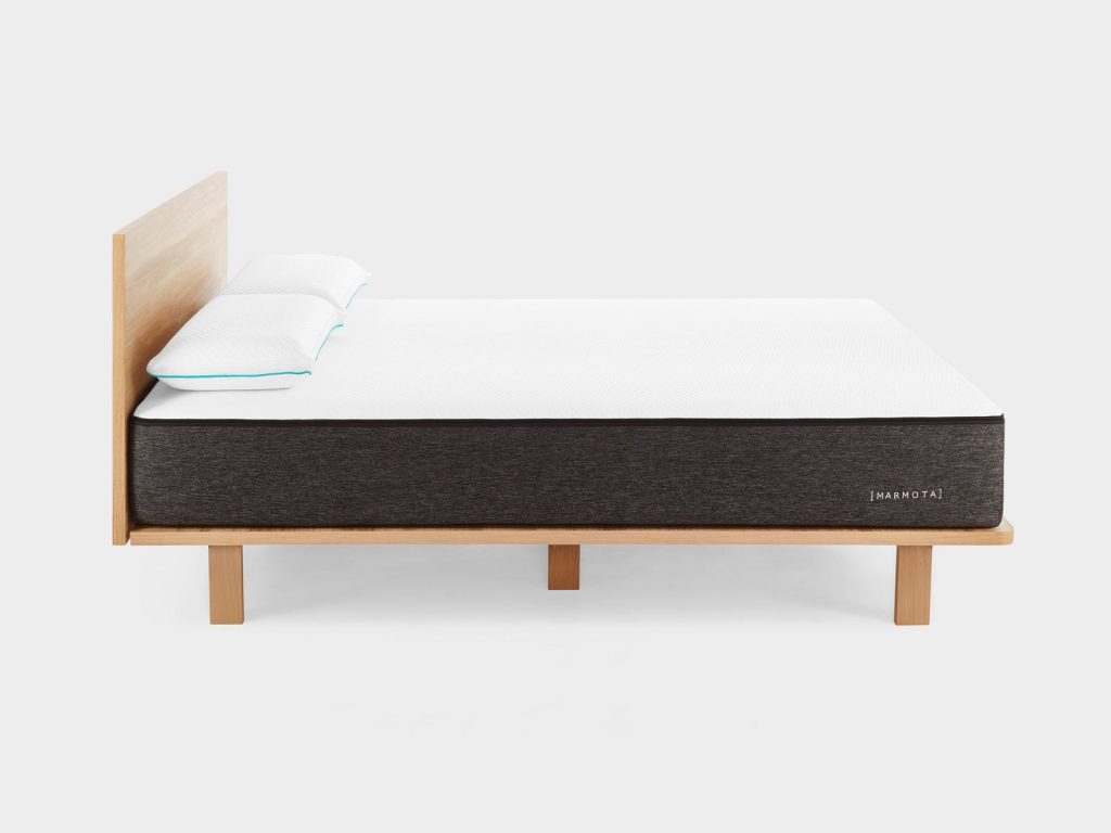 Marmota Hybrid sobre una cama de madera con almohadas