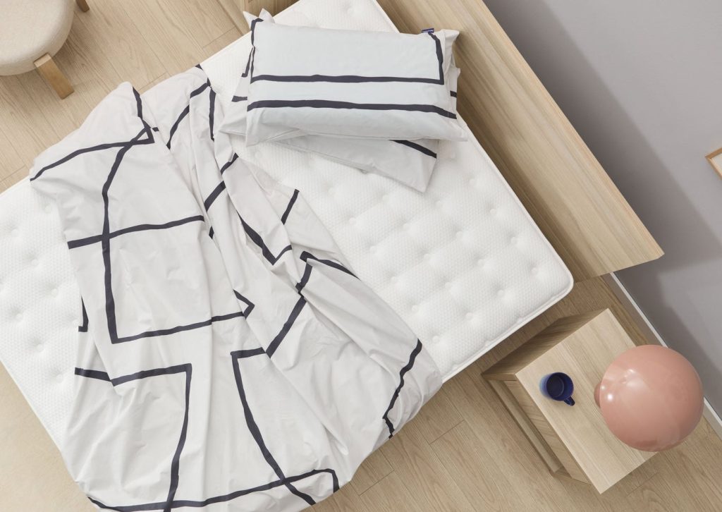 Marmota Hybrid Luxe Edition con ropa de cama en un dormitorio
