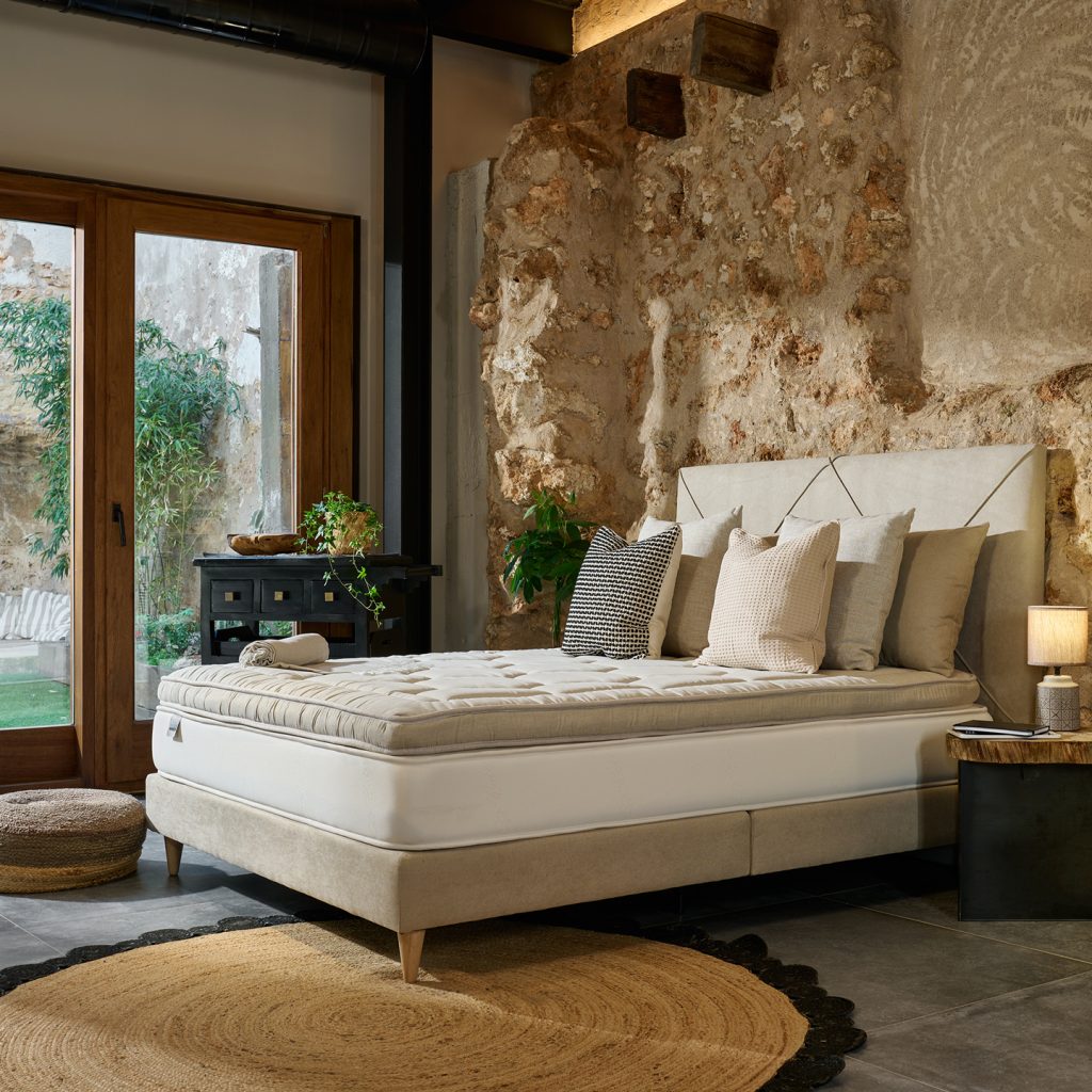 MaxColchón Topper Látex Aspen sobre una cama en un dormitorio rústico