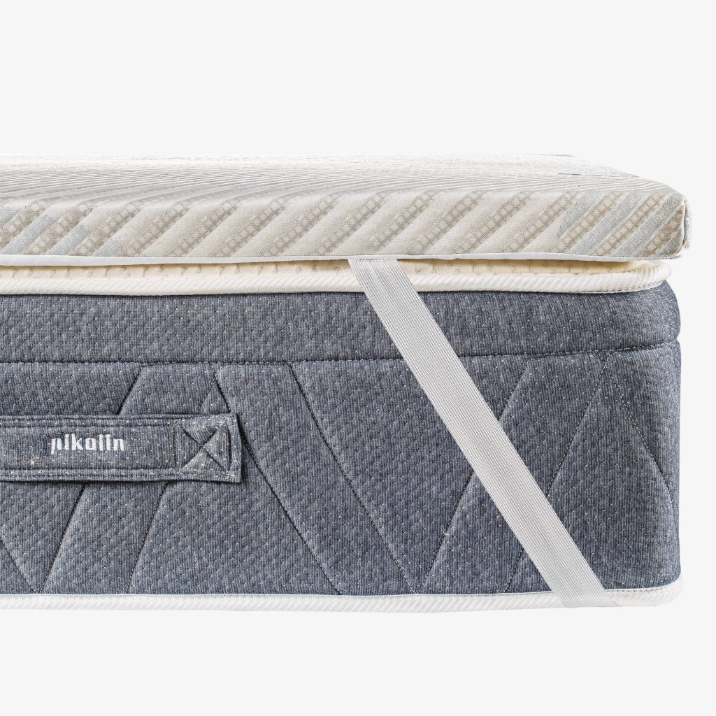 Pikolin Topper Coolpik sobre un colchón gris, vista lateral con banda elástica
