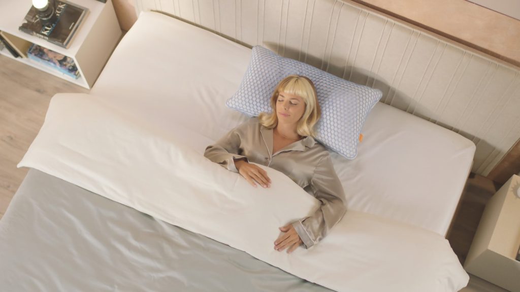 Mujer durmiendo boca arriba sobre la almohada Emma Microfibra Elite