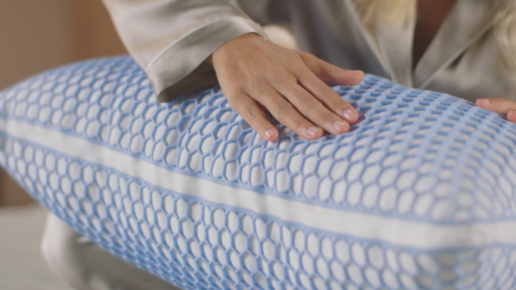 Mano sobre la funda AirGrid de la almohada Emma Microfibra Elite