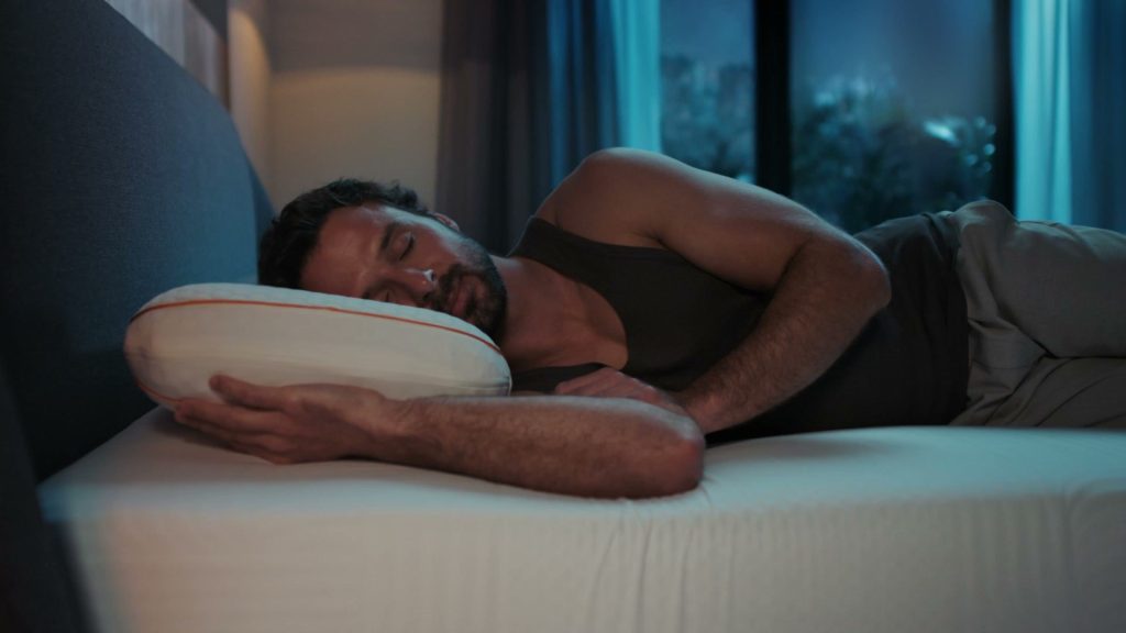 Hombre durmiendo de lado sobre la almohada Emma Performance Adapt