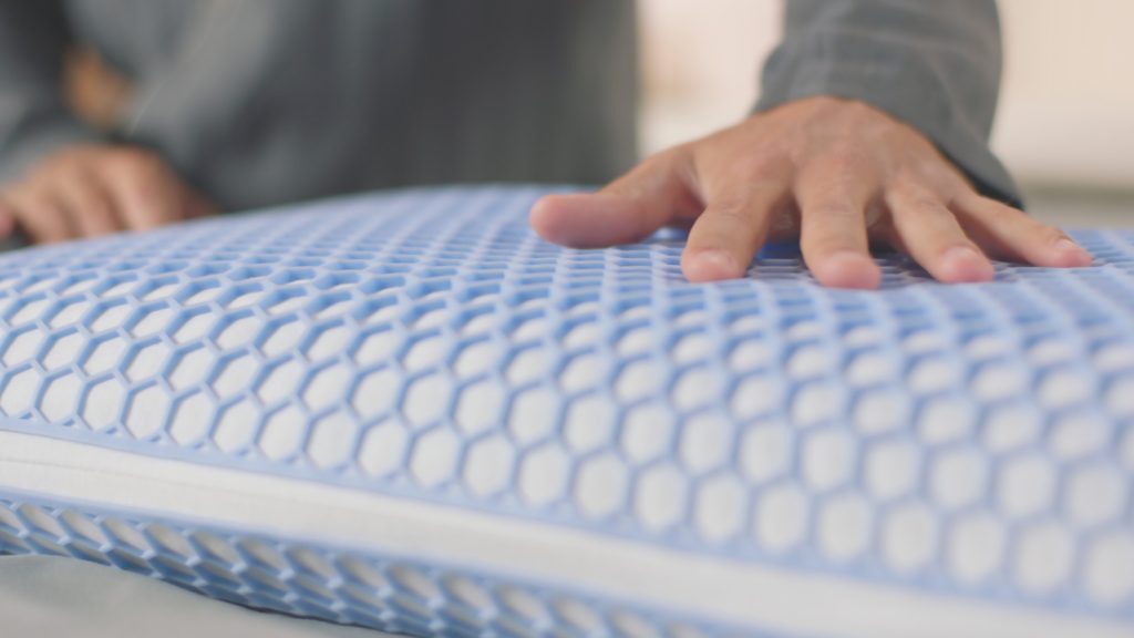 Mano sobre la funda AirGrid de la almohada Emma Viscoelástica Elite