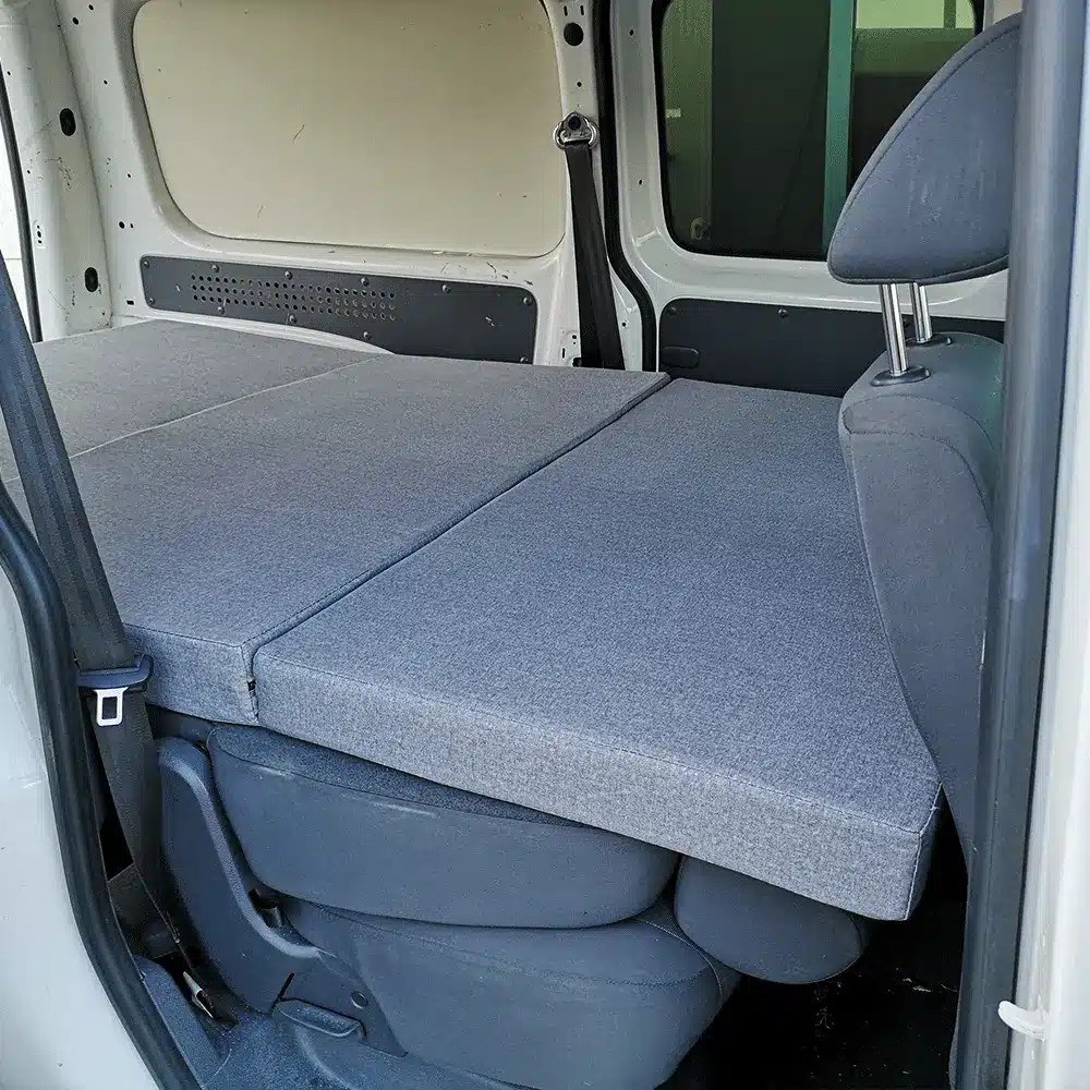 Colchón plegable K'Foam Mini Camper sobre los asientos abatidos de una furgoneta pequeña