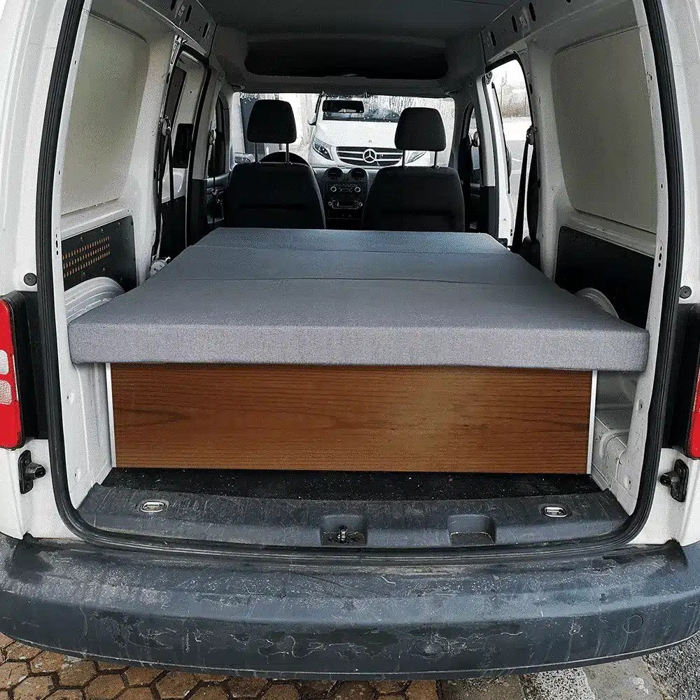 Colchón plegable K'Foam Mini Camper sobre un mueble de madera en el maletero de una furgoneta