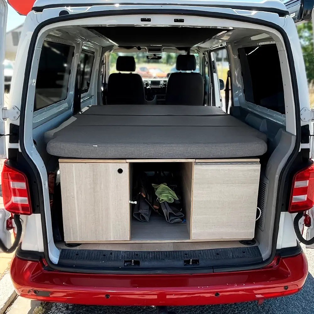 Colchón plegable K'Foam montado en la cama trasera de una Volkswagen T5, visto desde el portón