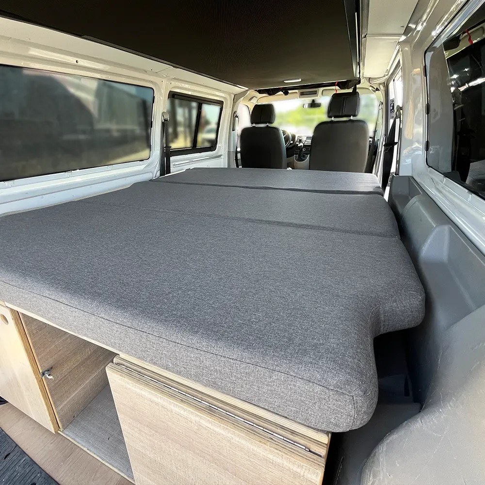 Colchón plegable K'Foam sobre la cama de una Volkswagen T5, vista lateral